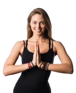 A woman is doing yoga in front of a black background.