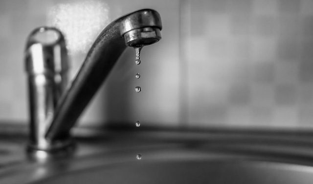 A faucet dripping water with three drops of water.