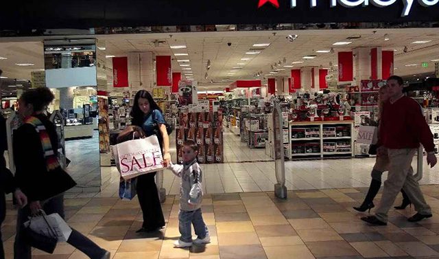 A woman and child walking in front of a store.