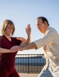 a man helping a woman with yoga